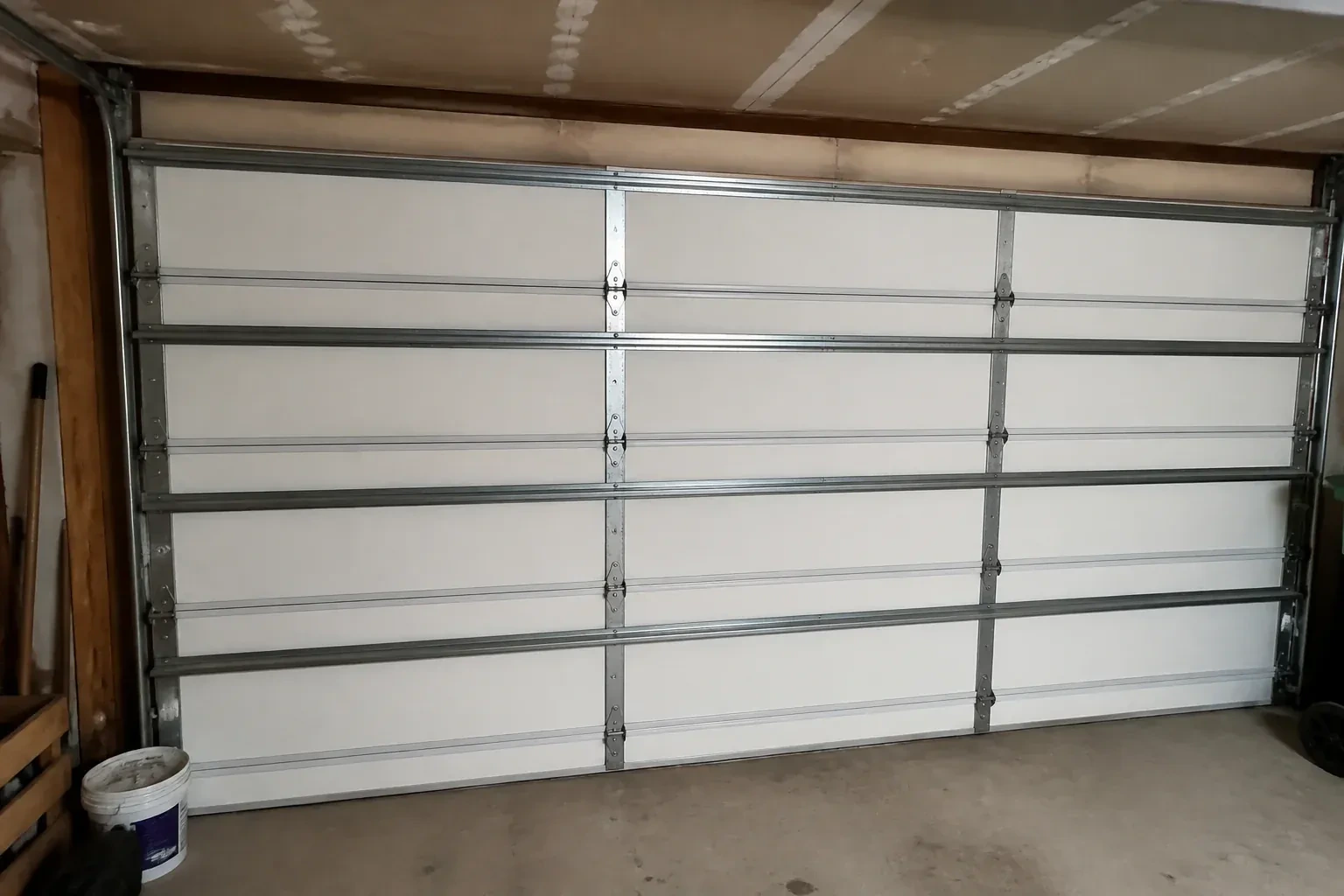 Interior of a closed sectional door with horizontal metal reinforcement struts. — Wind-Rated Garage Door Replacement, London